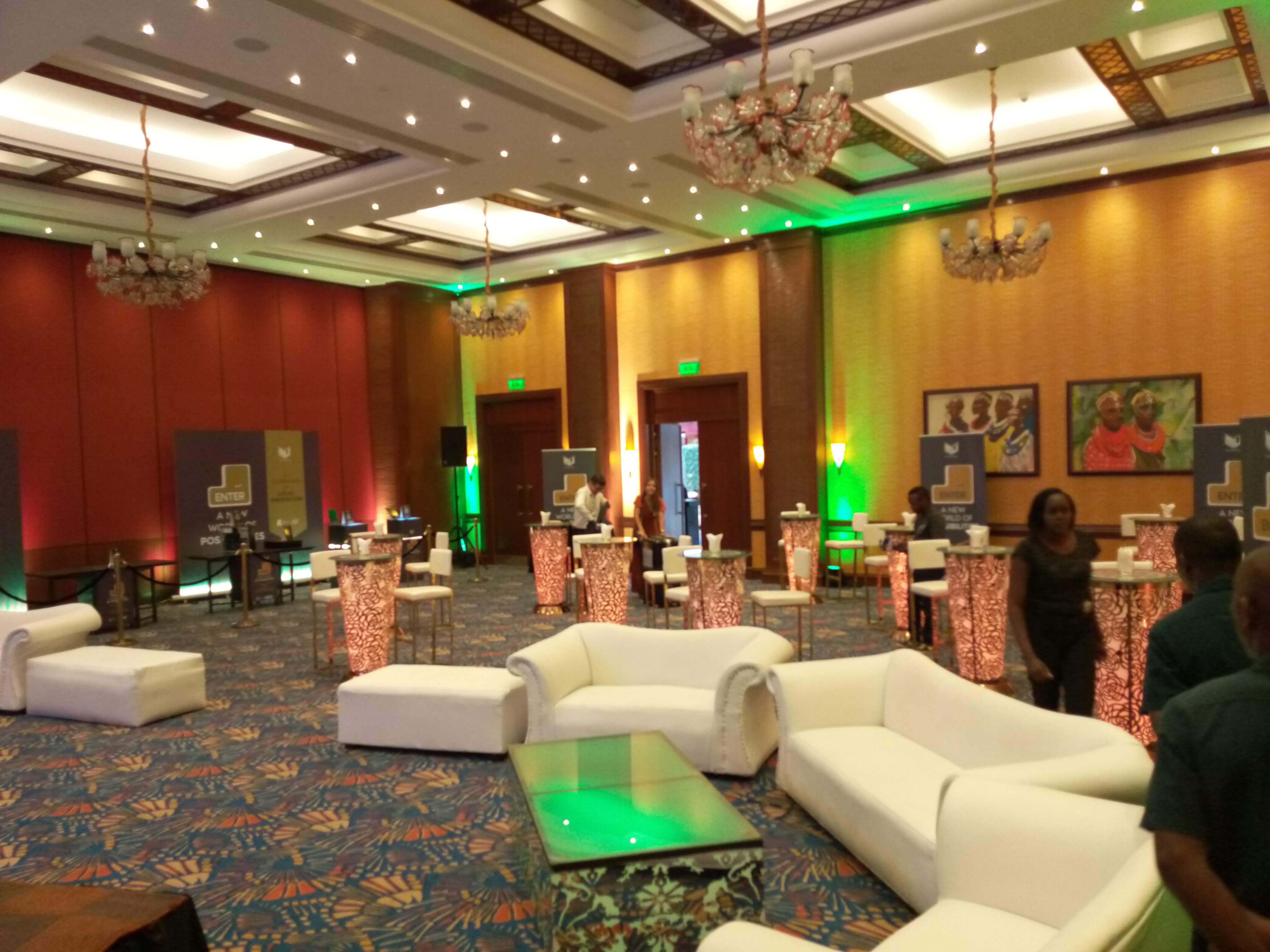 Banquet hall with gold-sashed white chairs facing a stage with ENTER conference branding